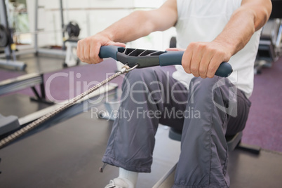 Fit man working out on rowing machine