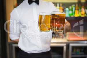 Bartender holding two glasses of beer