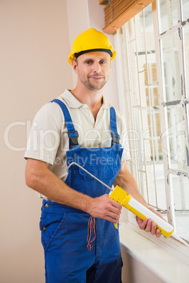 Man putting filling between window and wall