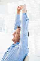 Happy businessman stretching his arms