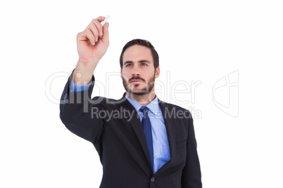 Businessman holding a chalk and writing something