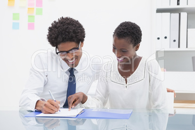 Smiling coworkers looking the document