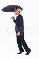 Businessman in straw hat under umbrella