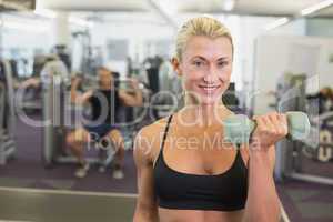 Woman exercising with dumbbells in gym