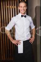 Handsome waiter posing and standing hands on hips