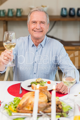 Smiling man toasting at christmas dinner