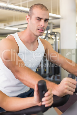 Man working out on exercise bike at gym