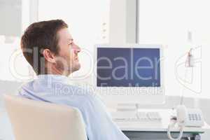 Smiling businessman sitting at his desk