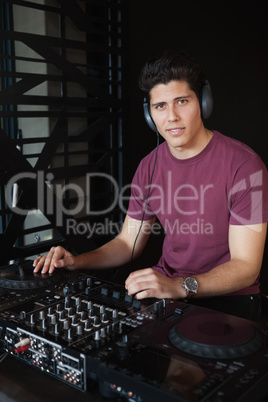 Cool dj working on a sound mixing desk