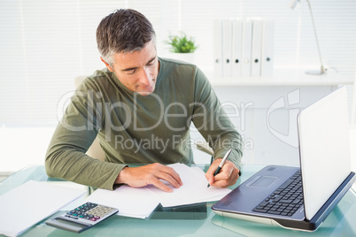 Man working with laptop and writing