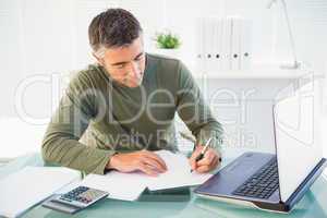 Man working with laptop and writing