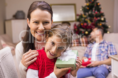 Daughter holding a gift with her mother