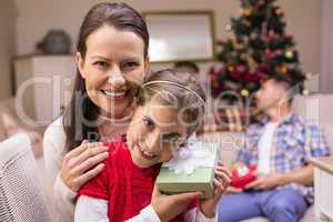 Daughter holding a gift with her mother
