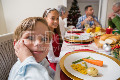 Portrait of little boy with a funny face at christmas dinner