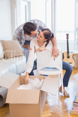 Cute couple unpacking cardboard boxes