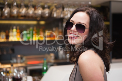 Pretty woman wearing sunglasses with tongue out