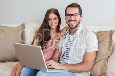 Hipster couple using laptop on couch