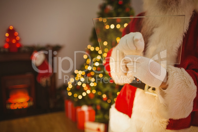 Mid section of santa writing list on glass