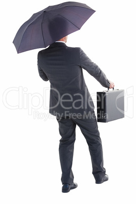 Businessman in suit holding umbrella and briefcase