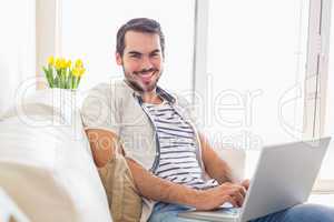 Hipster man using laptop on couch