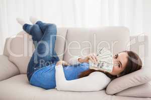 Pretty brunette showing cash on couch