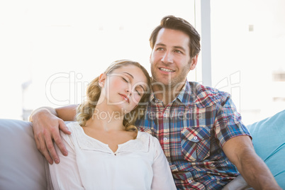 Girlfriend lying on the shoulder of her boyfriend on the sofa