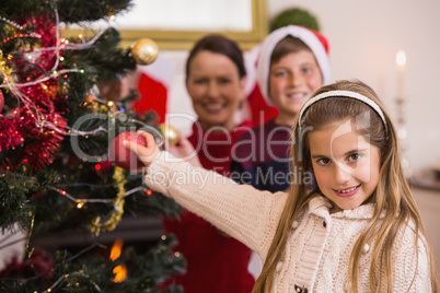 Smiling little girl decorating the christmas tree