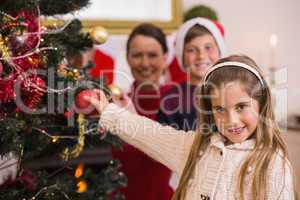 Smiling little girl decorating the christmas tree