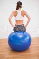 Fit brunette working out with exercise ball