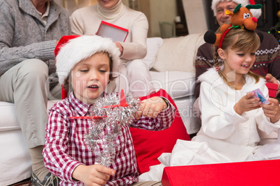 Festive little siblings opening gifts