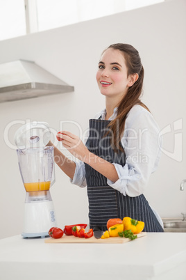 Pretty brunette making a healthy juice