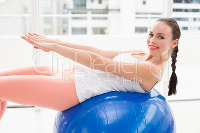 Fit brunette stretching on an exercise ball