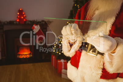 Mid section of santa writing list on glass