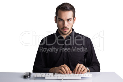 Serious businessman typing on keyboard