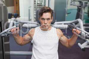 Fit man using weights machine for arms