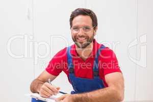 Construction worker taking notes on clipboard