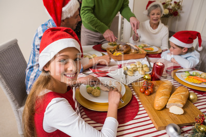 Portrait of cute girl in santa hat during christmas dinner