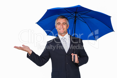 Happy businessman under umbrella with hand out