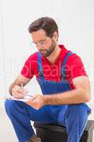 Construction worker taking notes on clipboard