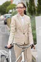 Young businesswoman standing with bike