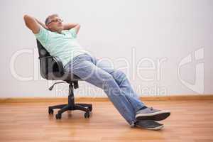 Mature man leaning back in swivel chair