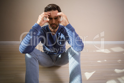 Depressed man sitting on floor