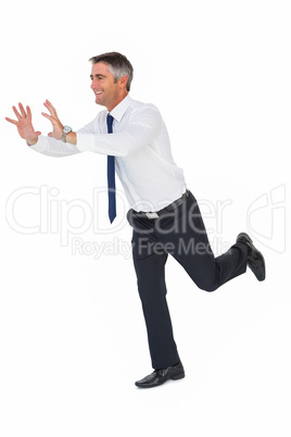 Happy businessman without jacket catching something