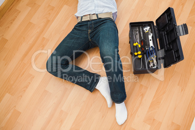 Man lying with a tools box near him