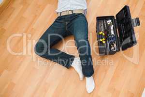 Man lying with a tools box near him