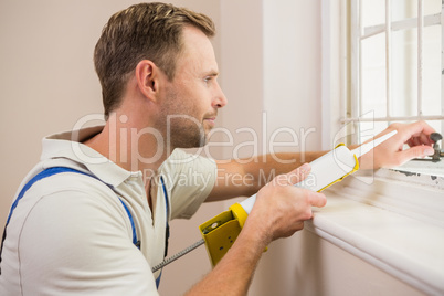 Man putting filling between window and wall