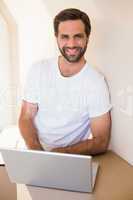 Happy man using laptop after moving in