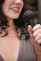 Close up of beautiful woman singing into a microphone