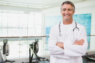 Confident doctor standing in fitness studio