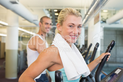 Fit young couple working on x-trainers at gym